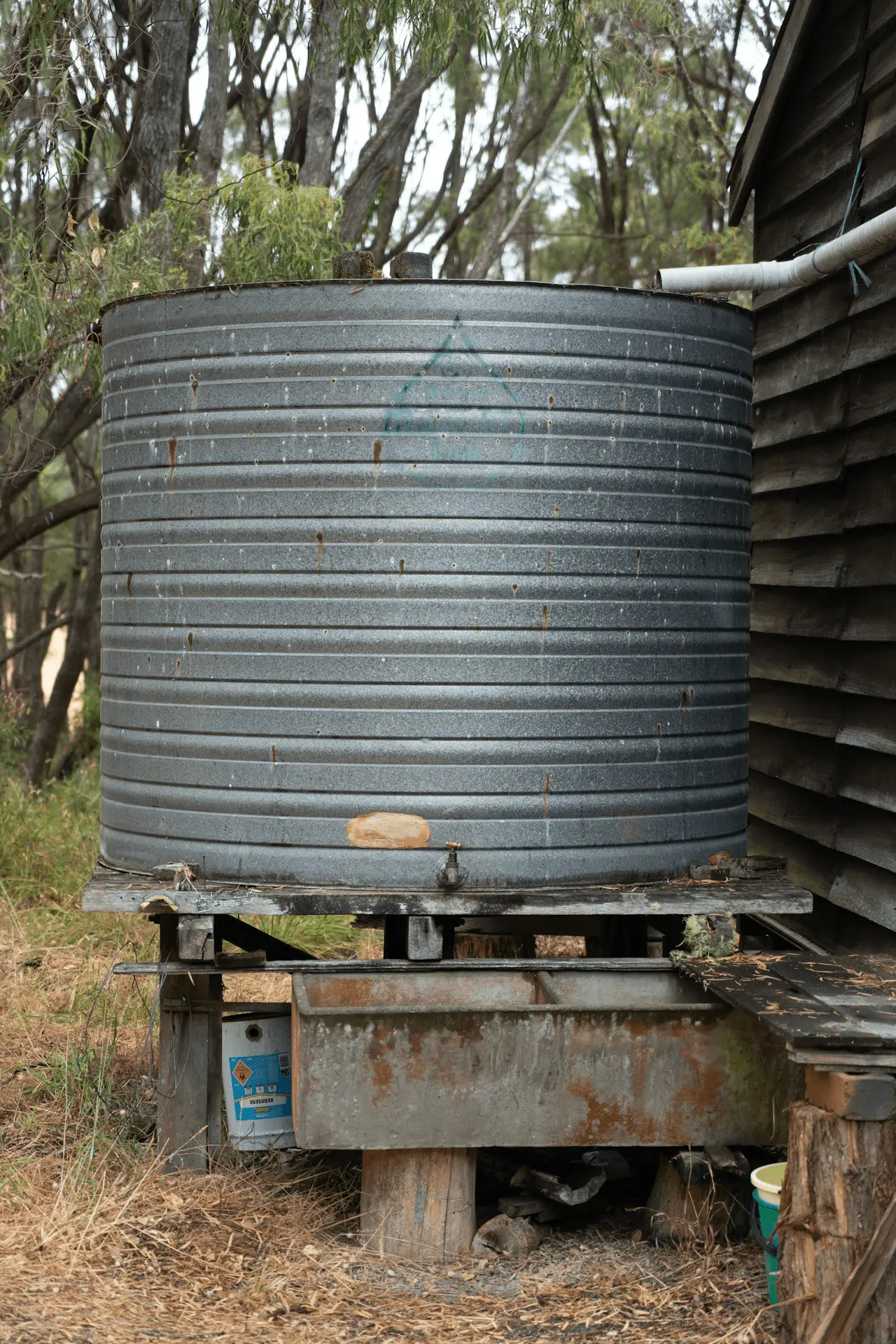 Cuve de récupération d'eau de pluie en métal galvanisé alimentée par la gouttière du toit