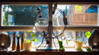 Rebord de fenêtre ouverte garni de plantes d'intérieur, symbolisant l'aération et la qualité de l'air