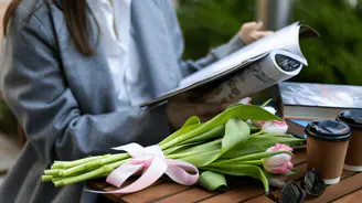 Lecture d'un magazine sur une table avec des fleurs autour, ambiance fraîche et informée — illustration de la catégorie Actualités.